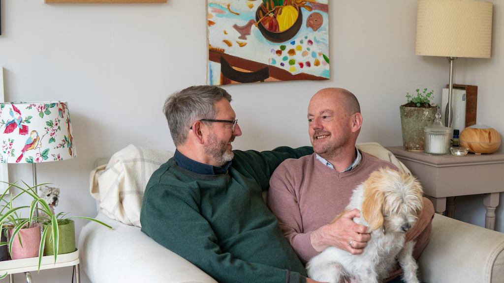 michael and his husband Johnny sitting together with their dog