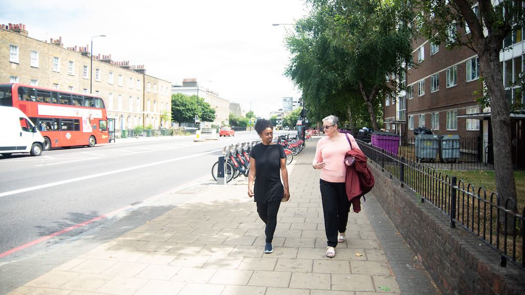 two older women walking down a sunny street