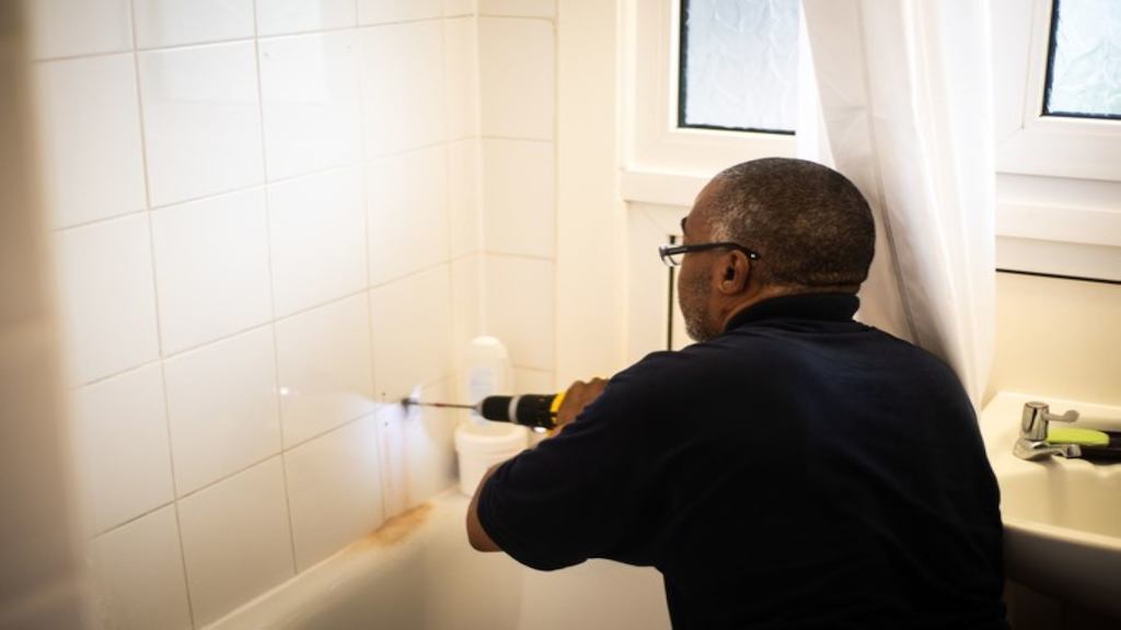 Image of a man with a drill making improvements to a bathroom