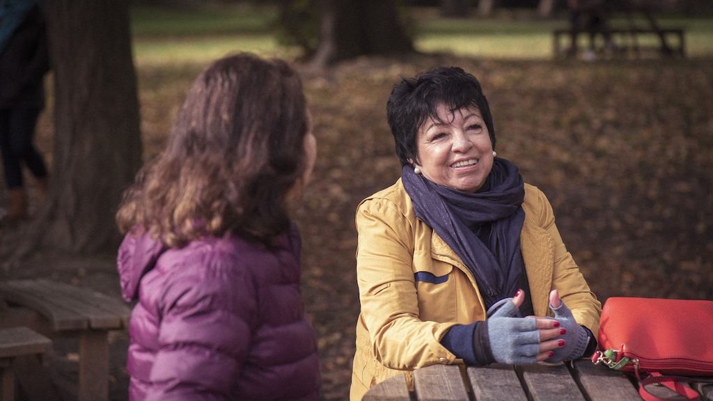 older women sitting together outside talking