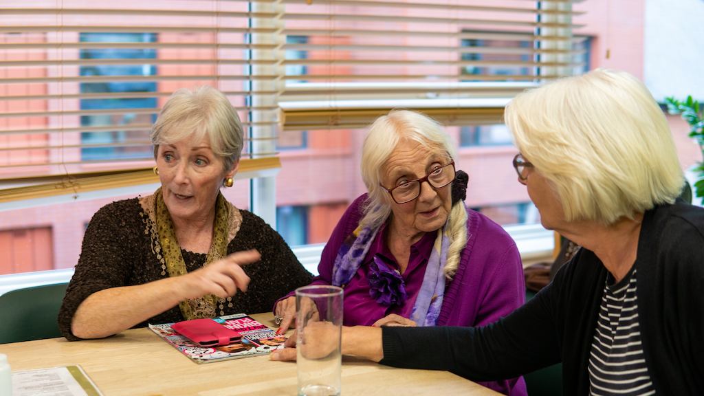 Group of older women sat together and talking
