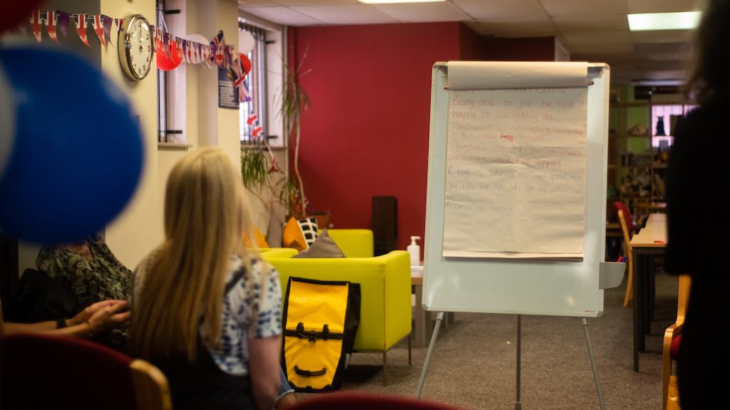 a group of people talking around a whiteboard