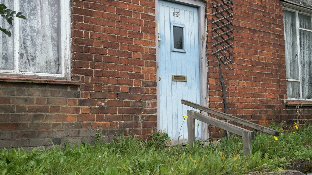front of a house with weeds