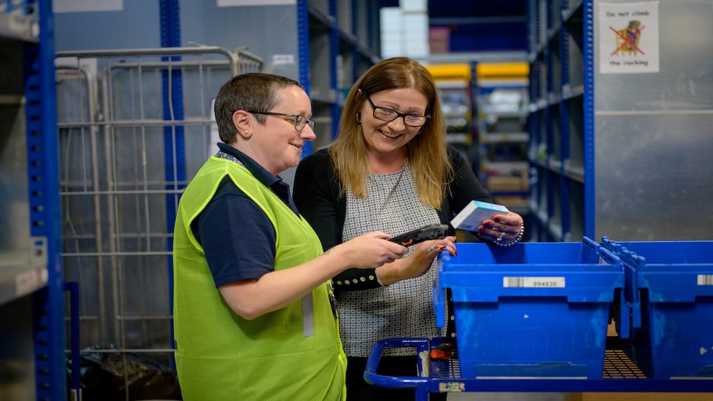 Two women examine products in a warehouse