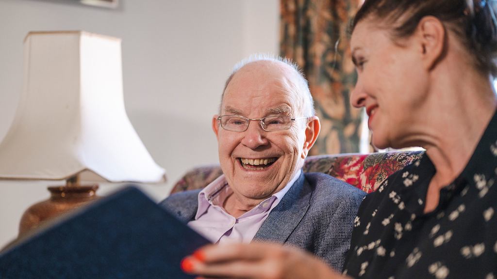 older man and woman reading together