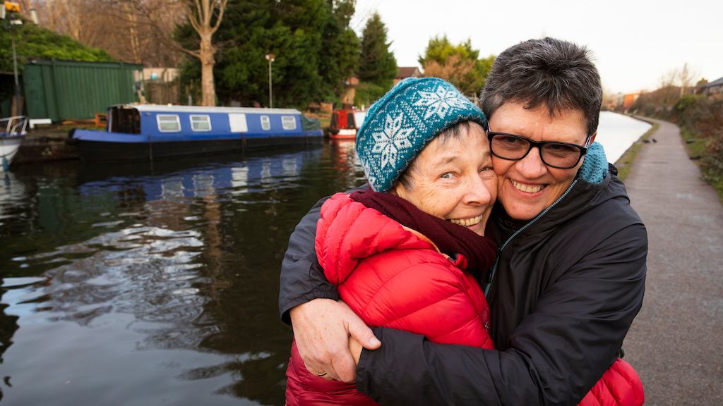 Jo and Liz hugging each other near a canal