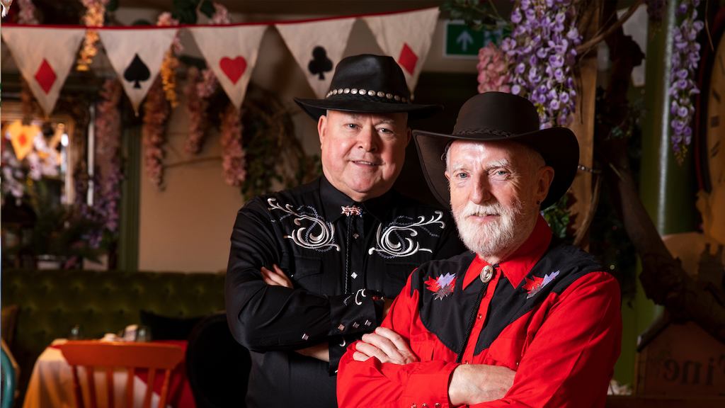 Patrick and David in their line dancing outfits smiling at the camera