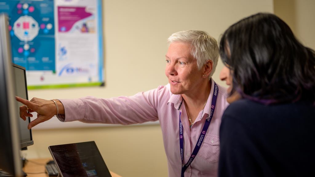 Two office workers working at a computer