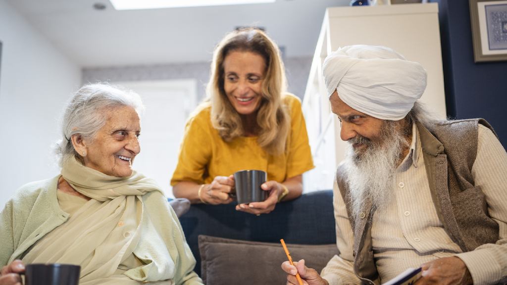 Group of older people sitting on a sofa and talking