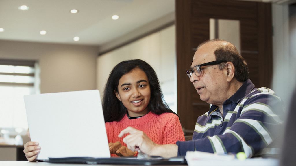 An older man and younger woman working together