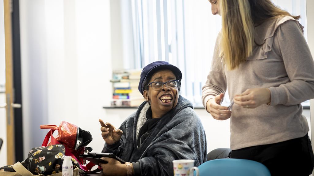Two women chatting with an iPad in frame