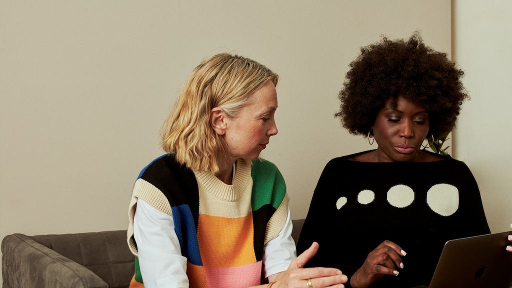 two women working from a laptop