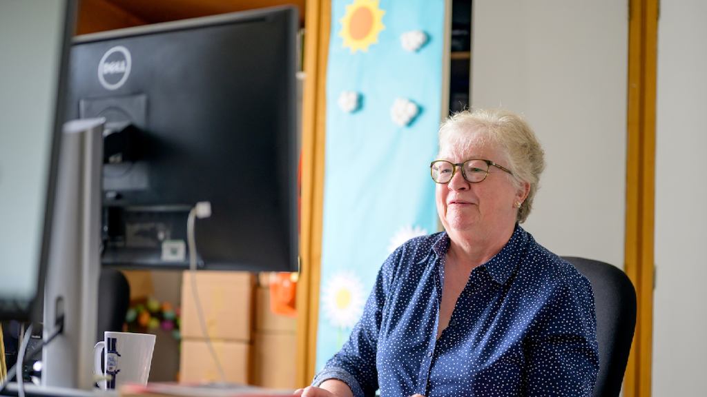 An older woman uses a computer
