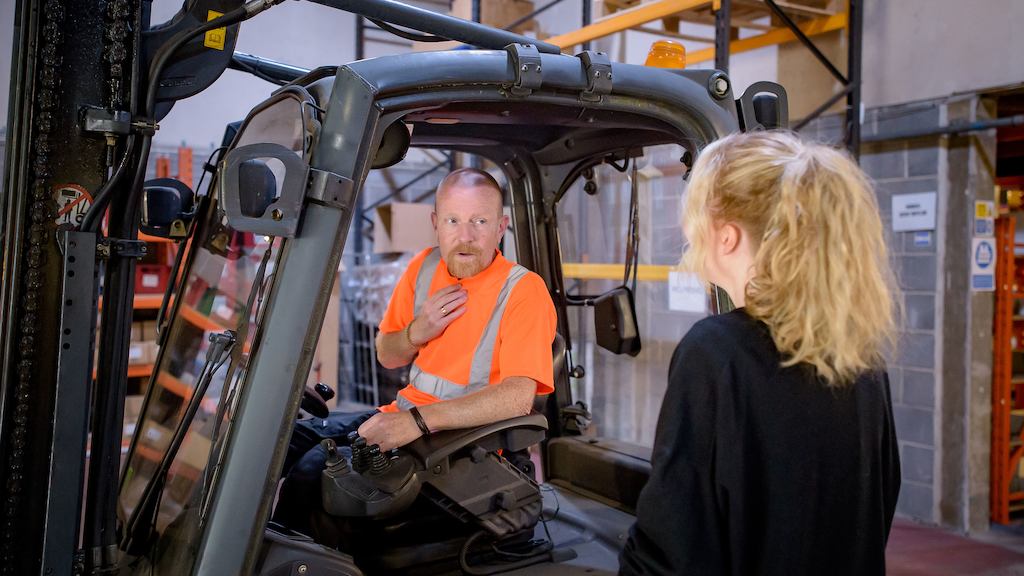 An older worker using a forklift