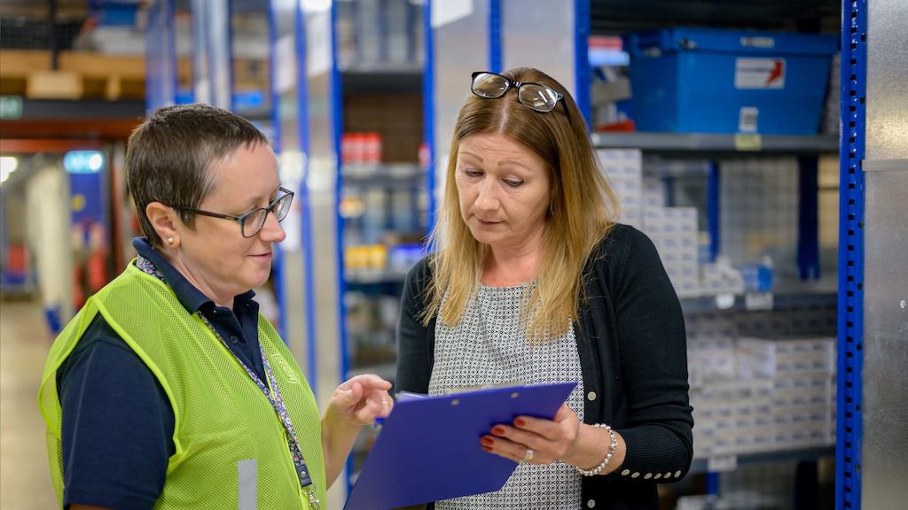 Two older workers in a warehouse