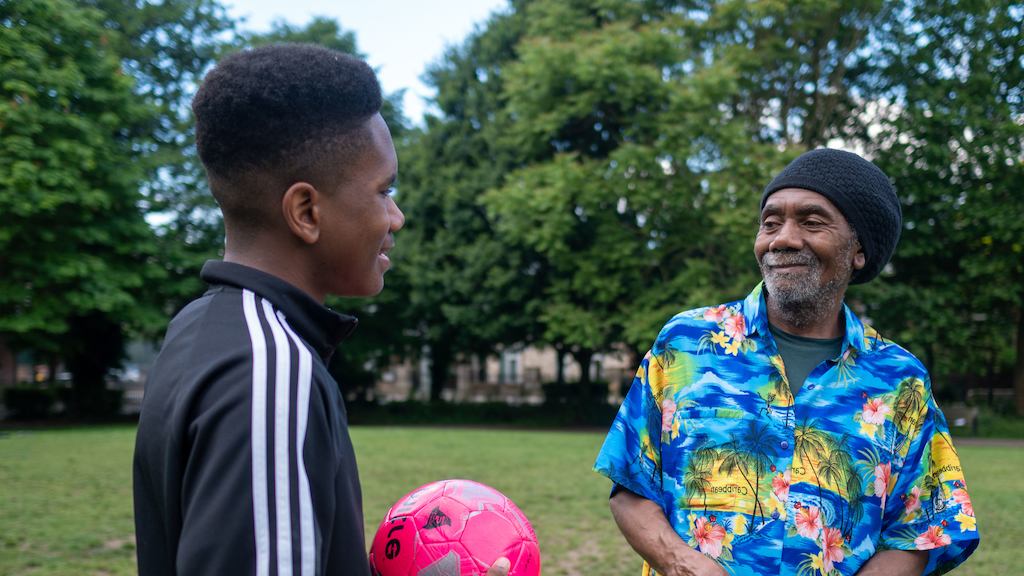 Older man playing football with his son