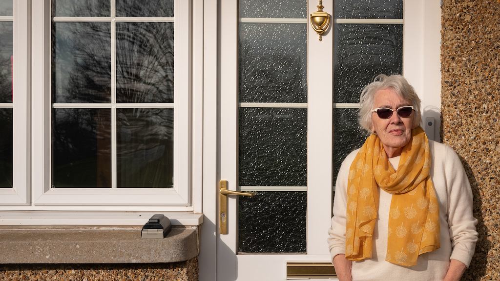 Older woman standing in front of a door