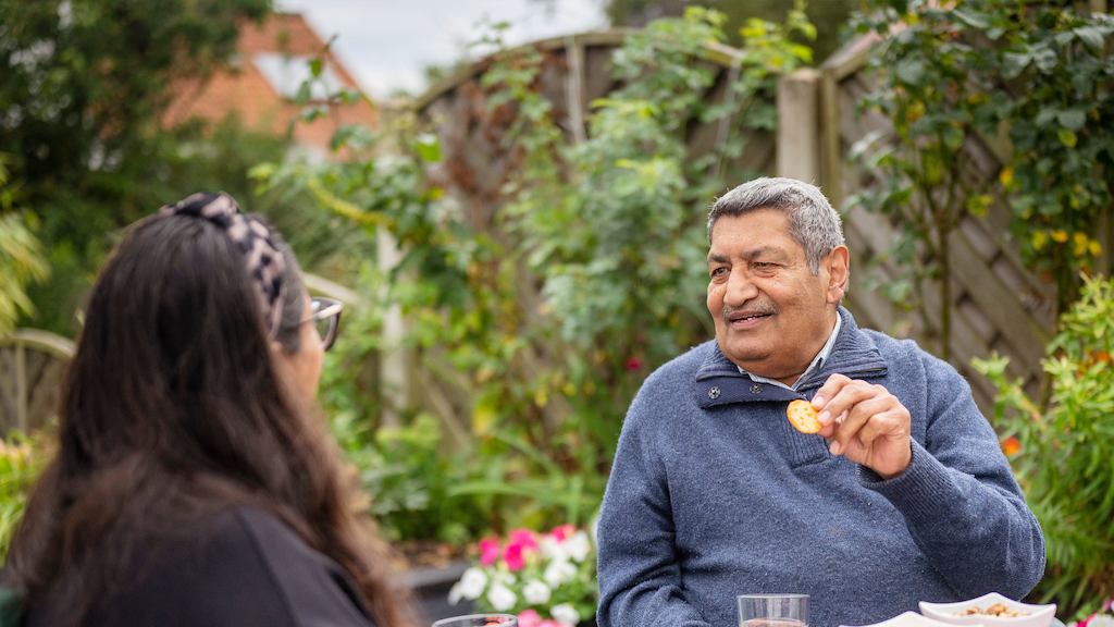 Older people outside having snacks