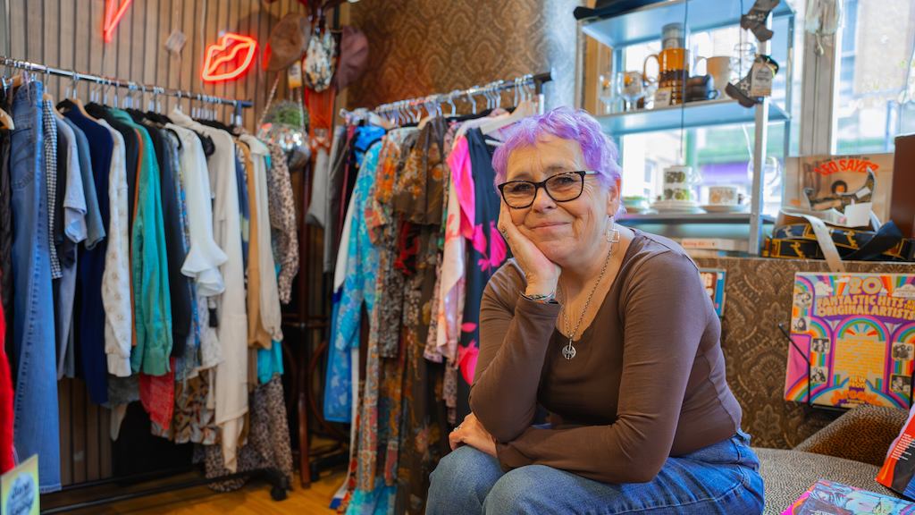 Woman in clothing shop smiling at camera