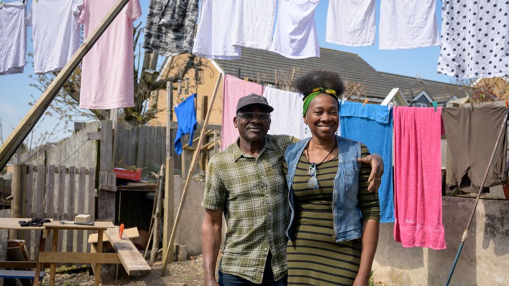 An older man and his daughter hang clothes on a washing line