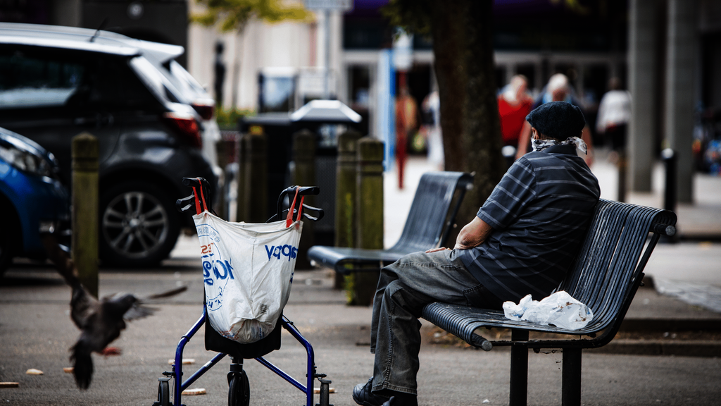 An older man sitting on a bench