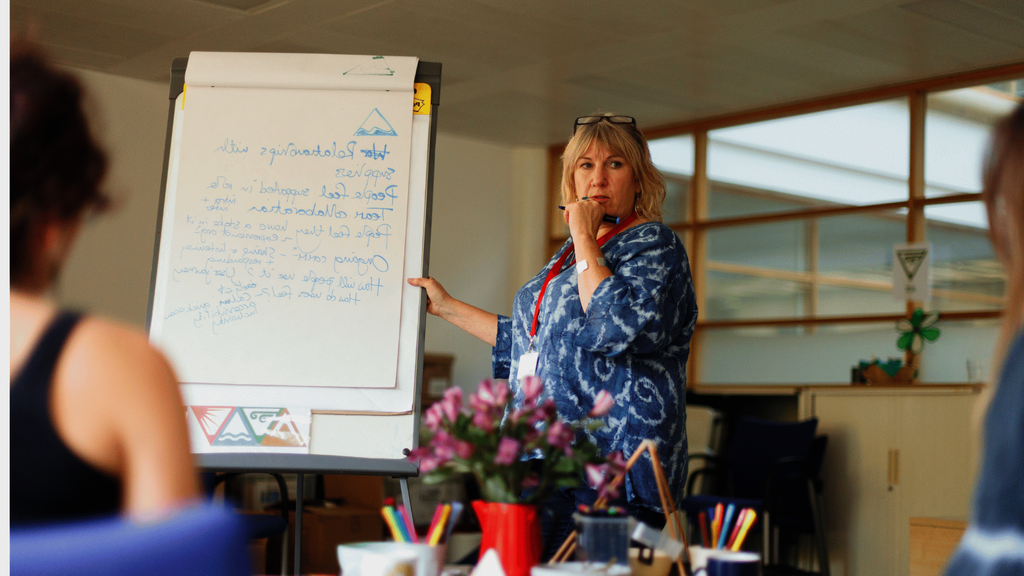 An older woman writing on a board