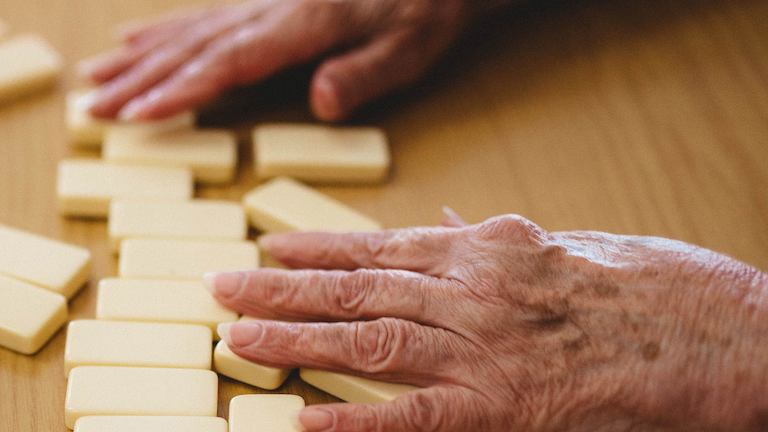 Elderly hands playing dominos.
