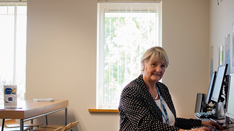 Older woman seated at computer.