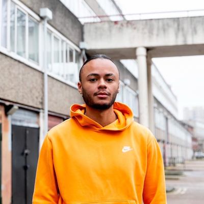 Kwajo Tweneboa in an orange hoodie