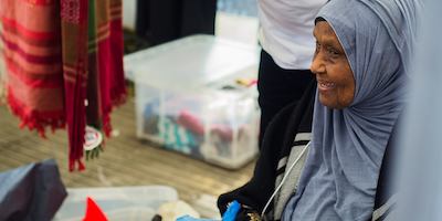 older worker sitting by stall