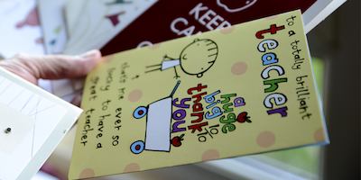 Teacher holding 'thank you' cards