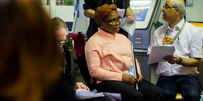 Visually impaired lady and a volunteer working through a quiz
