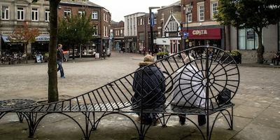 Two women sitting on a bench in Macclesfield