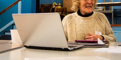Woman seated at a table, using a laptop