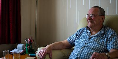 Older man sitting on chair in home