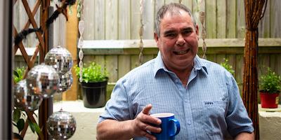 Man in a garden holding a mug of tea