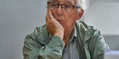 Elderly man sitting alone in thought.