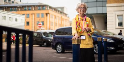 Older woman hospital volunteering standing outside hospital.