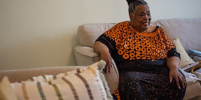 Woman seated on sofa at home.