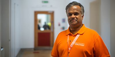 Older Indian male volunteer in hospital setting.