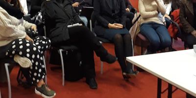 Women sitting in a room for a conference.