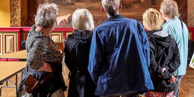 Group of elderly people in a museum looking at a work.