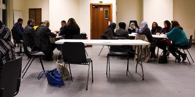 People seated at tables at job centre.
