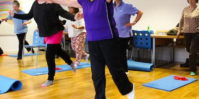 Women in physio yogalates class doing a balancing pose.