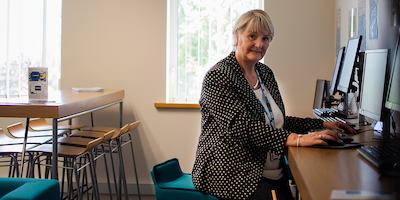 Older woman seated at computer.