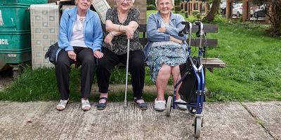 Three ladies in later life sitting on a bench