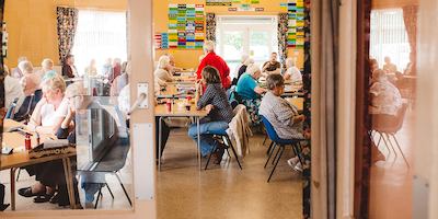 Group of older people sitting by tables