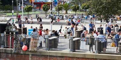 Group of people enjoying the sun by a bridge