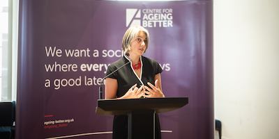 Anna Dixon on a podium giving a speech