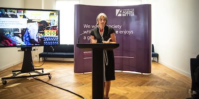 Anna Dixon on a podium giving a speech